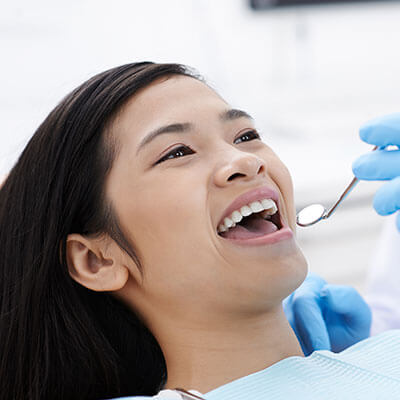 A young woman being checked by her dentist