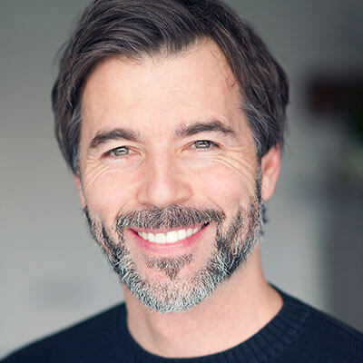 A mature man with a beard wearing a black sweater